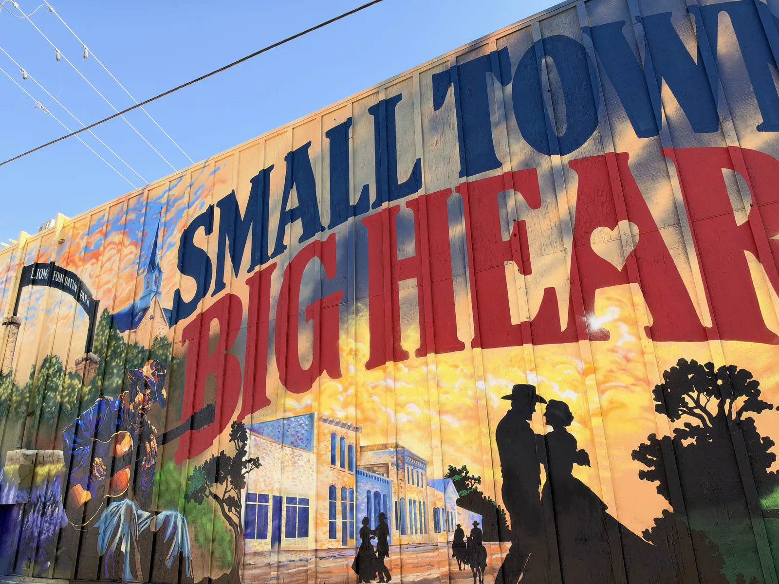SMALL TOWN BIG HEART lettering over the painted downtown skyline on the finished Parkers wall