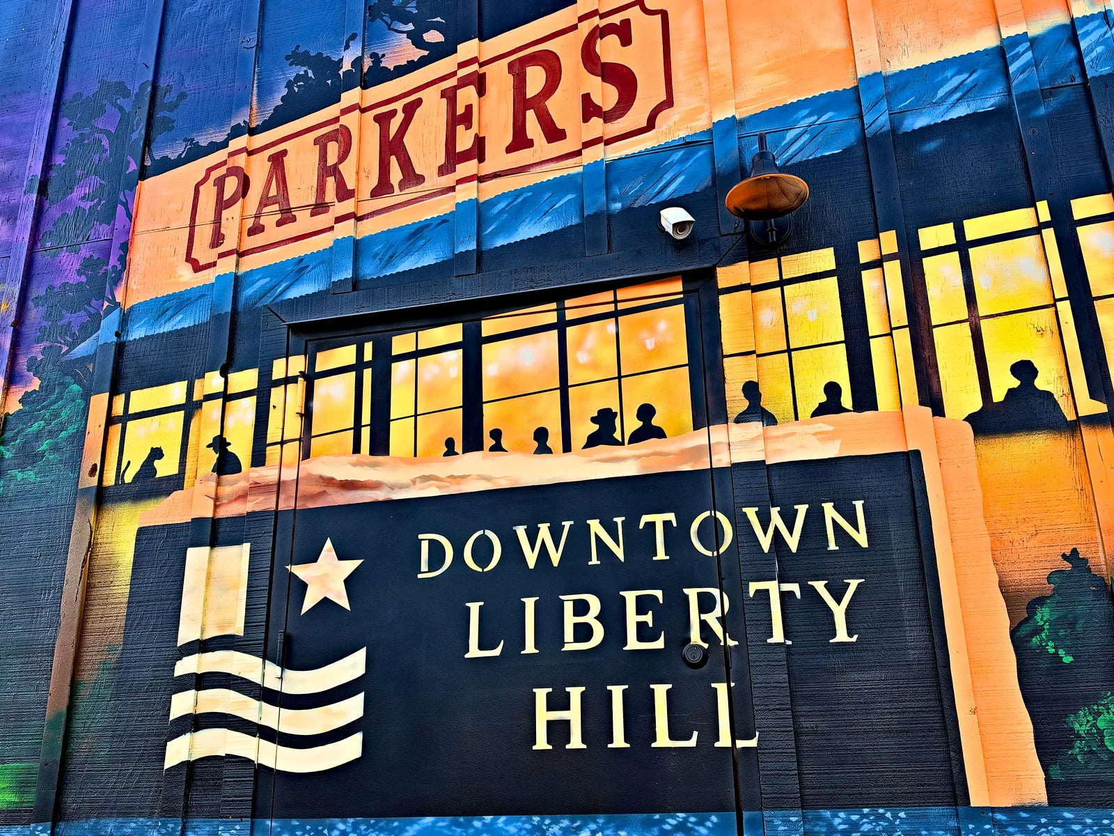 PARKERS storefront and DOWNTOWN LIBERTY HILL sign painted on the finished mural