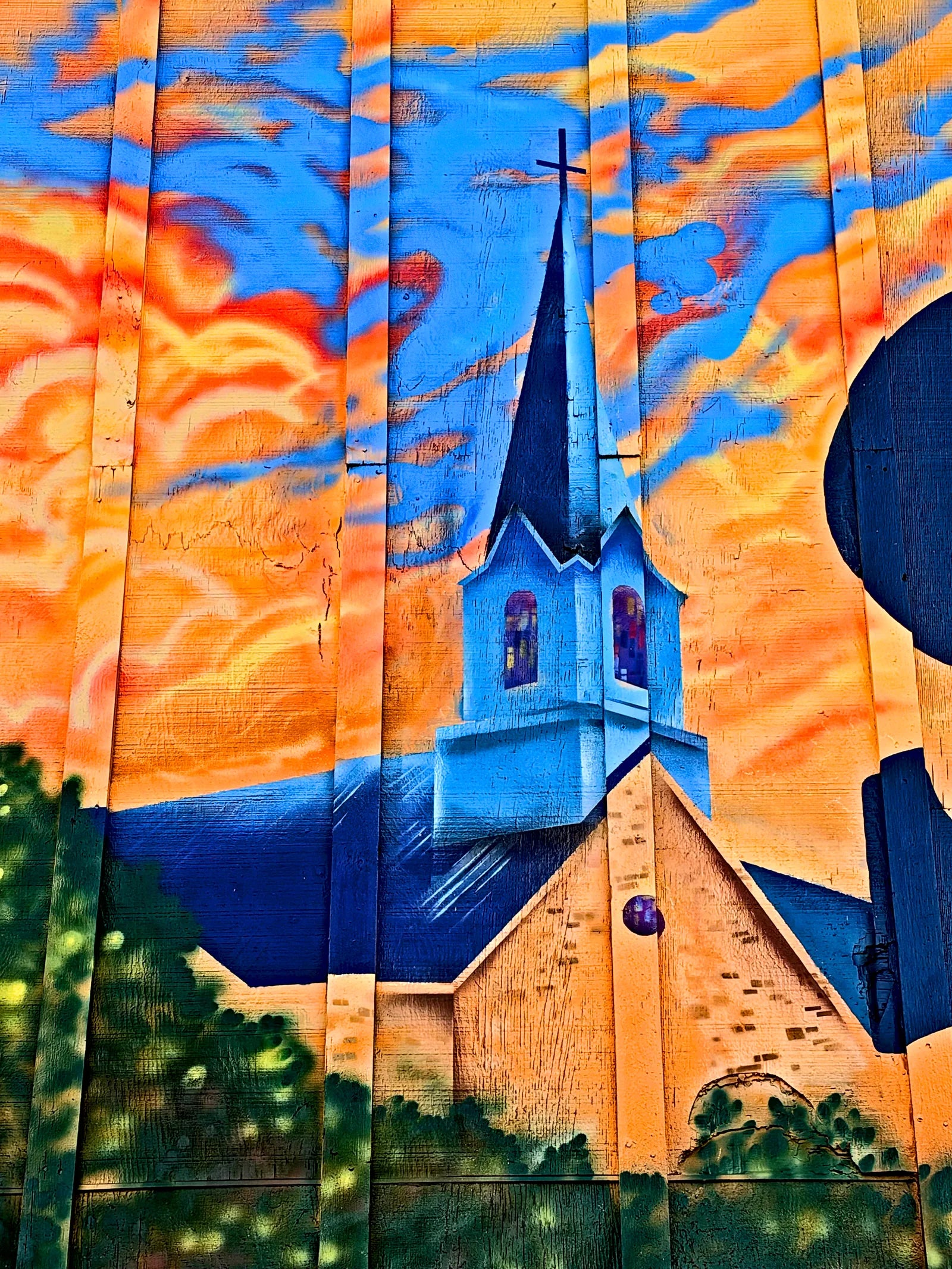 White church steeple rising into a sunset sky on the Parkers mural
